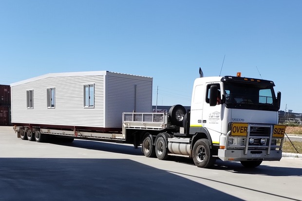 Oversized truck transporting a prefabricated modular unit to a construction site, highlighting Rapid Modular WA's efficient logistics and transport services in Perth.