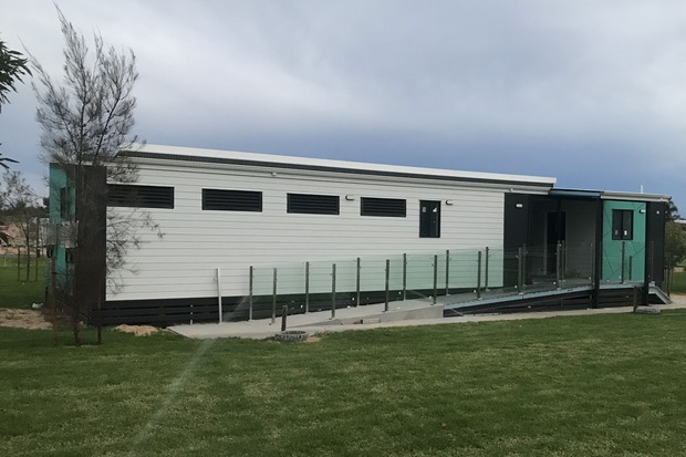 Modern modular building with glass railing and wheelchair-accessible ramp, designed by Rapid Modular WA for inclusive housing and public spaces, showcasing eco-friendly and adaptable construction solutions for Perth and Western Australia.