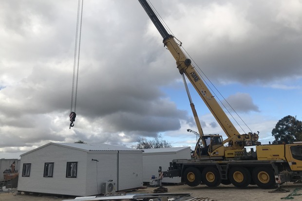 Heavy-duty crane lifting a prefabricated modular building, demonstrating Rapid Modular WA's advanced construction techniques and efficient installation processes across Perth.